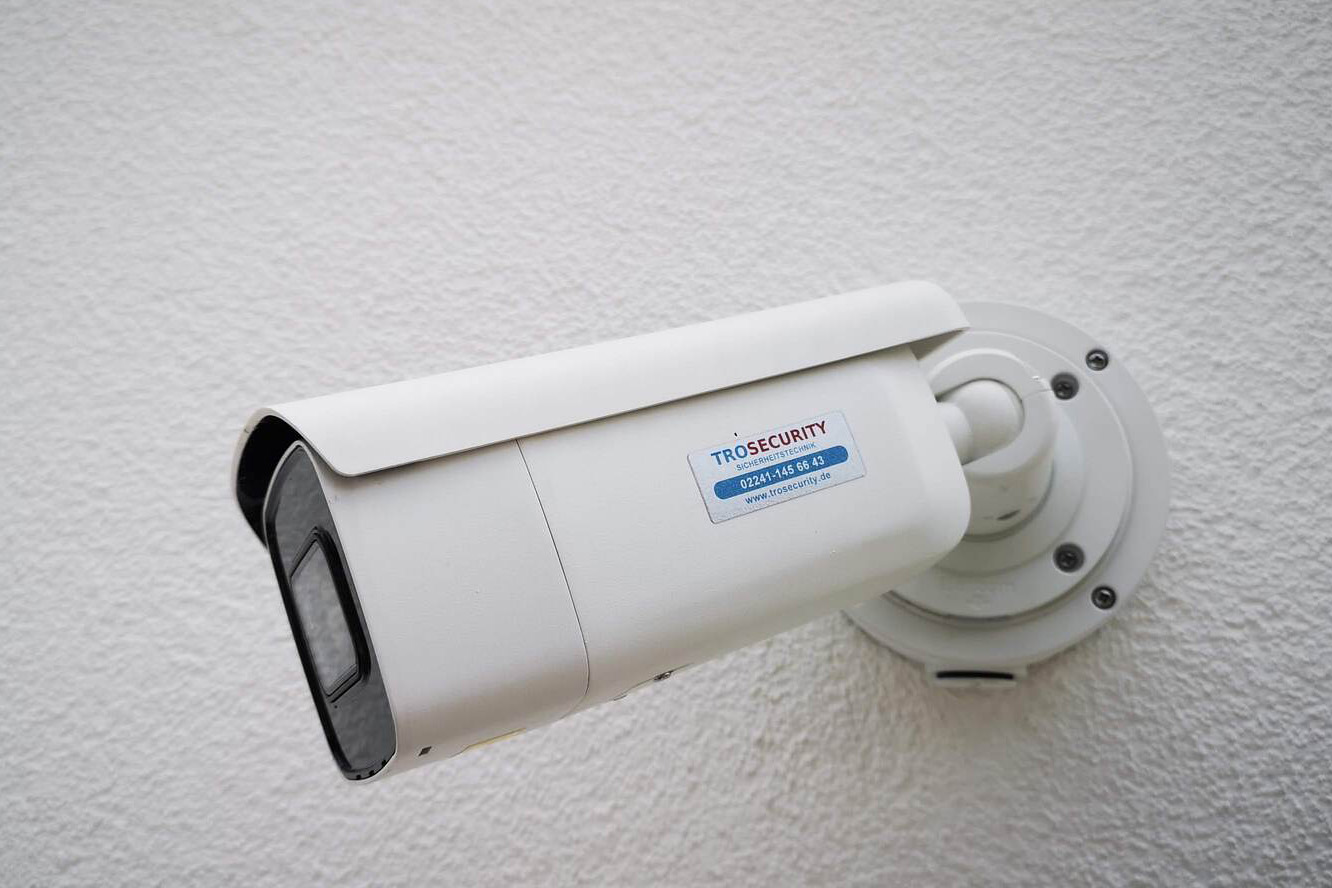 Eine an einer Außenwand montierte Überwachungskamera, wie TROSECURITY sie einsetzt. Absicherung Überwachung Sicherheit Troisdorf