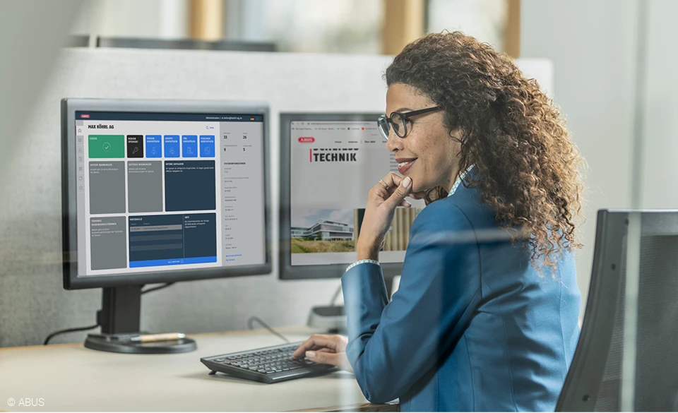 Eine Frau sitzt vor einem Monitor, auf dem der TECTIQ-Schließplan zu sehen ist.