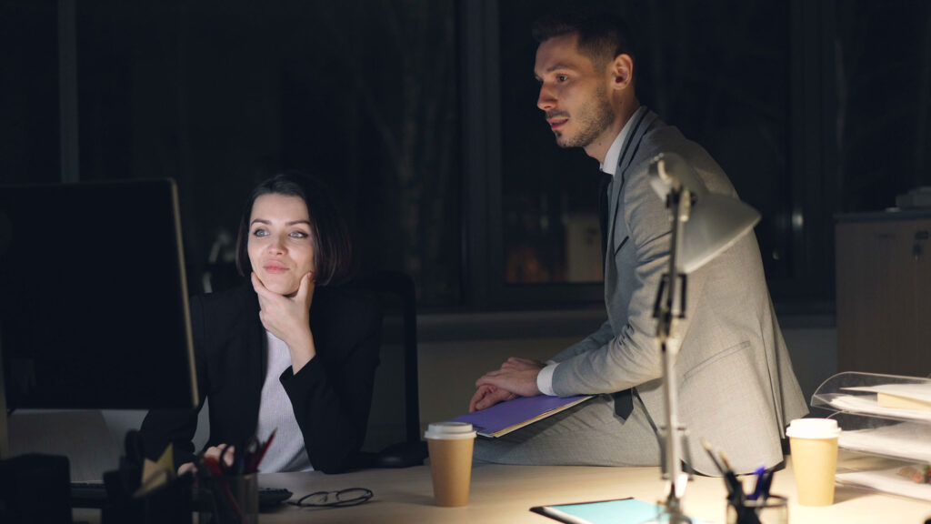 Eine Frau und ein Mann in einem dunklen Büro